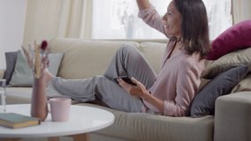Sequence of shots footage of relaxed woman relaxing on sofa consulting doctor online while staying at home