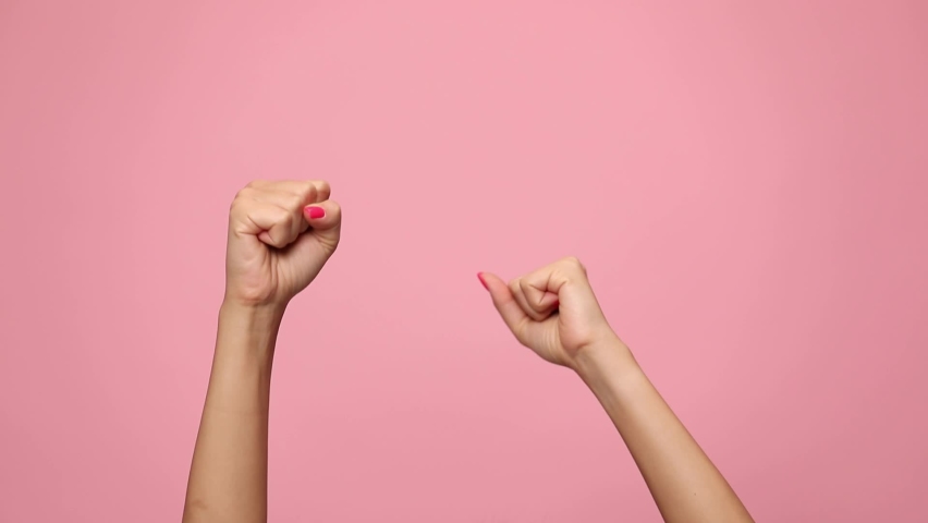Woman hands pointing fingers, making thumbs up gesture and celebrating victory on pink background | Shutterstock HD Video #1059324443