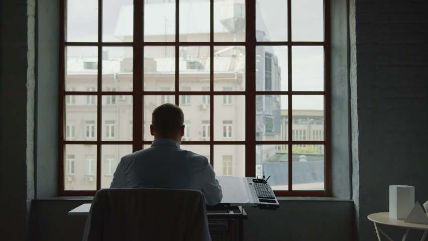 Young man with photo frame in office