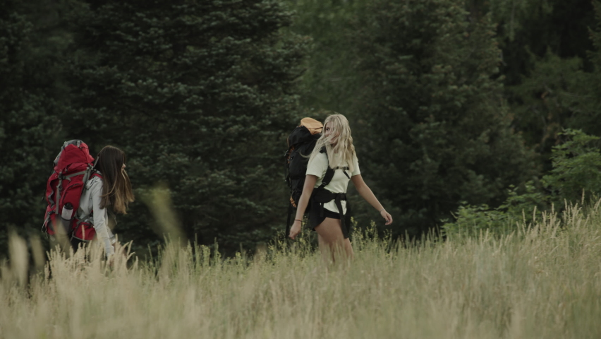 Distant teenage girls talking and hiking in field / Tibble Fork, Utah, United States