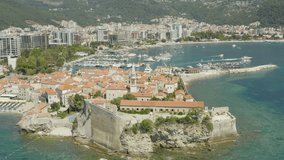 Aerial shot Budva Montenegro. Drone video of a city on the Adriatic coast surrounded by mountains with a beautiful landscape, with the old and the new city.