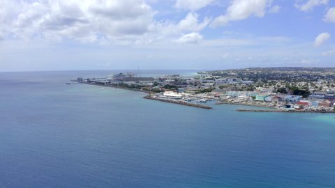 Flight in Barbados, Bridgetown from Carlisle Bay towards Bridgetown Harbour Cruise Pier where a cruise ship is docked. Drone flying above parked boats and descending in hight.