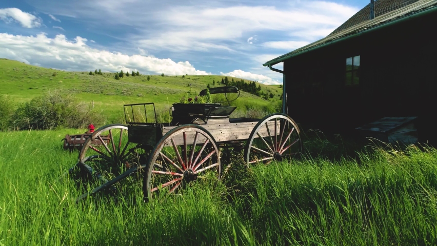Montana Landscape sunset old horse drawn carriages in summer vintage effect green grass all arround