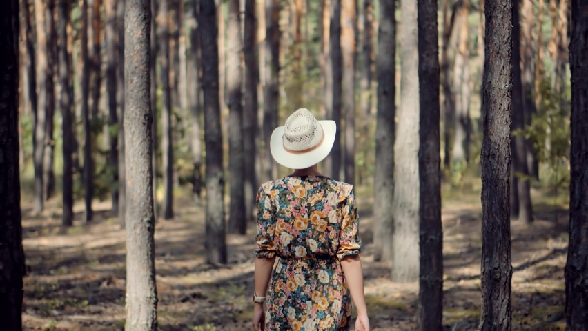 Beautiful Healthy Girl In Dress Walking In Greenwood. Carefree Female Exploring Green Forest In Sunny Time. Holiday Vacation Tourist Trip In Forest Warm Day. Active Woman In Hat Walking On Tree Park Royalty-Free Stock Footage #1059368651