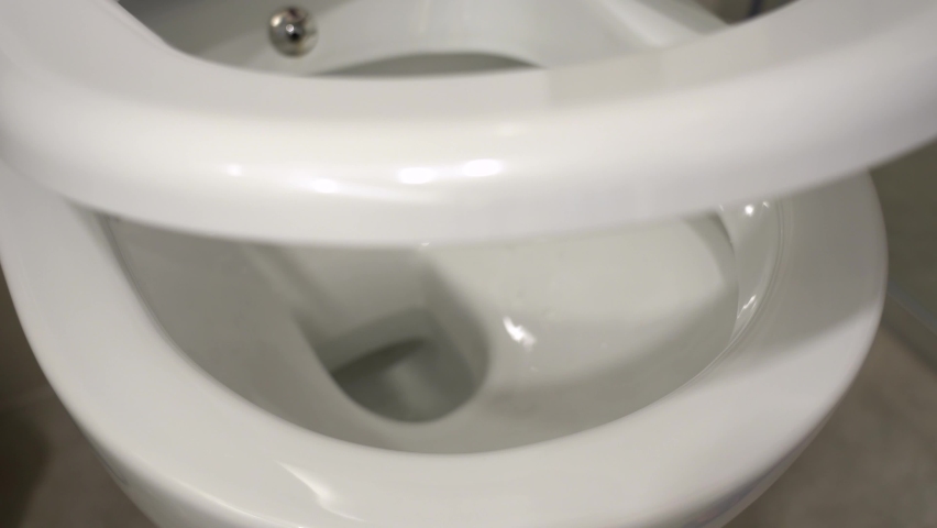 Closeup view 4k video of toilet bowl with modern automatic closers of seat lid and top cover lid. | Shutterstock HD Video #1059370304