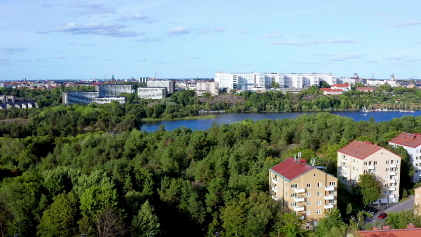 Lake in Stockholm, Sweden, Scandinavia. Aerial drone summer flying view of suburb Årsta with tall apartment houses.