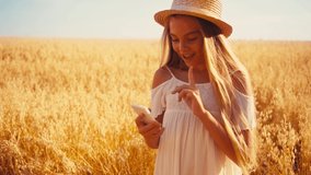 girl in white dress taking selfie and showing peace sign in wheat field