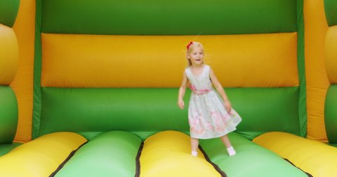 Girl (6-7) jumping in bouncy castle / Dinton, Wiltshire, UK