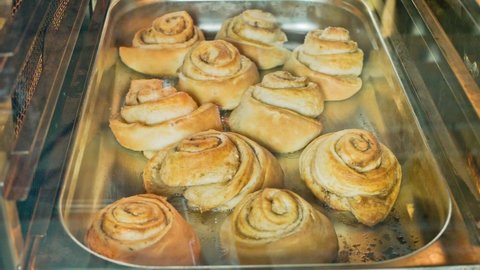Cinnamon rolls are cooked in the oven. The process of cooking in a fast shot. Timelaps.