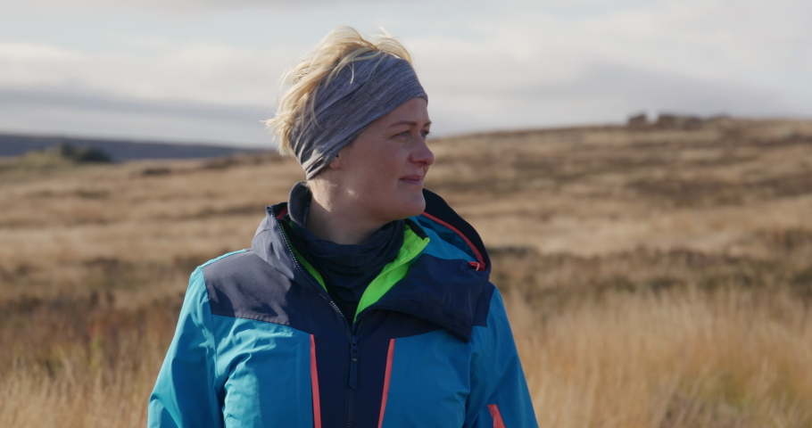 Portrait of mature woman in landscape / Yorkshire Moors, Yorkshire, UK