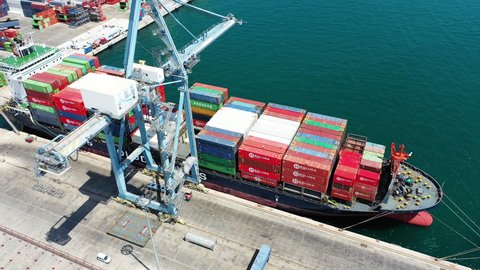 ALICANTE, SPAIN – JULY 19, 2020. Aerial view of the container ship VERONICA B docked and downloading the containers by means of gantry crane in the port of Alicante.