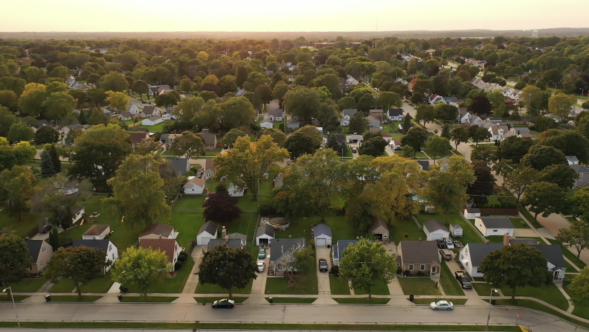 Aerial drone view of American suburban neighborhood at daytime. Establishing shot of America's  suburb. Residential single family houses pattern, trees