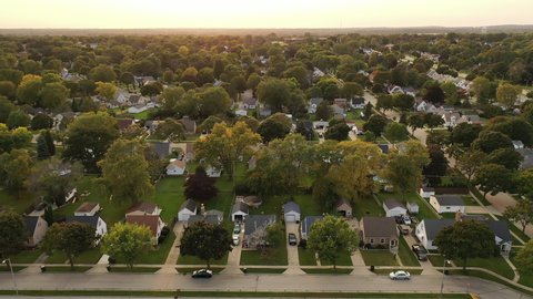 Aerial drone view of American suburban neighborhood at daytime. Establishing shot of America's  suburb. Residential single family houses pattern, trees