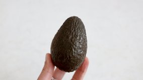 Avocado green and ripe holding in hand, high-fat and low carb diet, healthy fruit