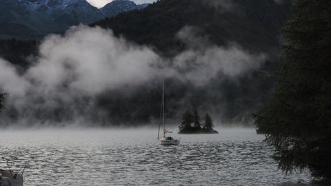 Maloja mountain Pass, Switzerland. September 15, 2020. Landscape of the lake Sils in the morning during the fall time. The fog covers the lake . Traditional Swiss contest. Natural landscape