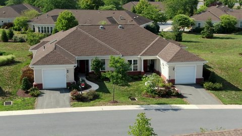 Aerial push-in shot of modern single-story duplex house, apartment in senior living community in United States, American 55 plus retirement, independent living for retirees, front facade with garages
