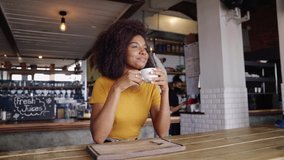 Beautiful mixed race teenage simply drinking hot coffee in stylish cafe