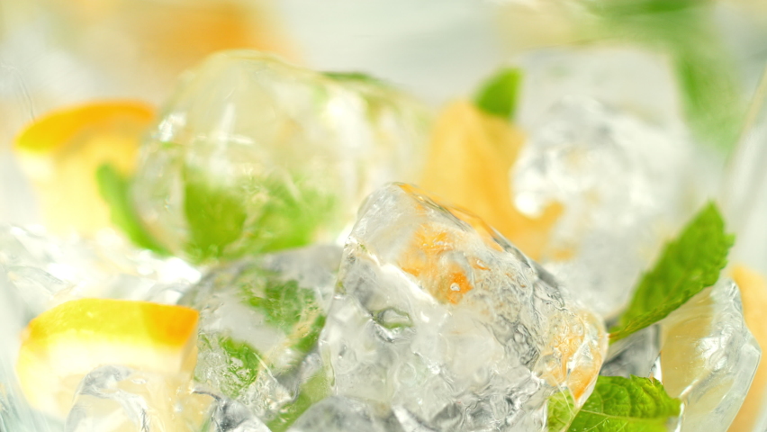 Pouring Water over Ice Cubes, Lemon Slices and Mint Making Lemonade in 1000fps Royalty-Free Stock Footage #1059455369