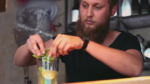 Barman With Long Beard Preparing A Mojito In A Cocktail Bar.