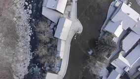 Flyover drone video of Rastoke, with man slack-lining over icy river