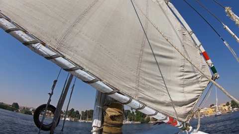 View from an Egyptian felucca boat sailing along the Nile River in Aswan, 4k