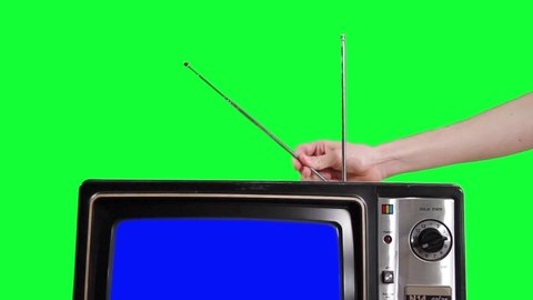 Man adjusting the Antenna of an Old Television with Blue Screen over Green Background. You can replace blue screen and green background with the footage or picture you want with “Keying” effect in AE.