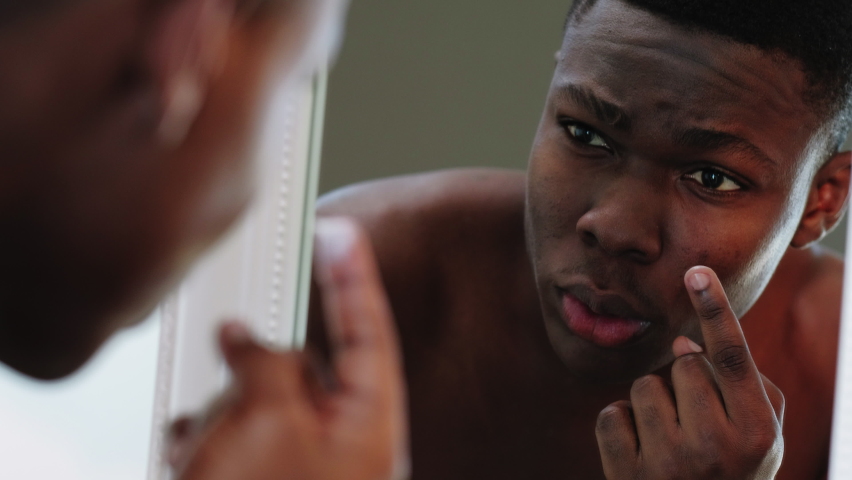 Male skincare. Facial treatment. Confident african man applying anti wrinkles lotion under eyes smiling satisfied looking in mirror. Morning routine. Dermatology hygiene. Metrosexual lifestyle. Royalty-Free Stock Footage #1059481757
