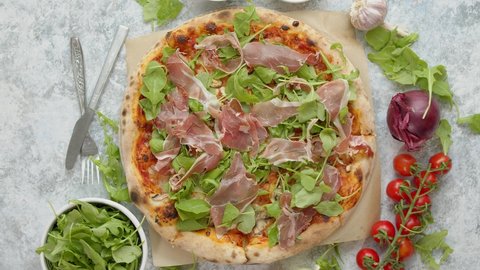 Pizza with prosciutto and arugula. Served with fresh ingredients on sides. Top view, flat lay