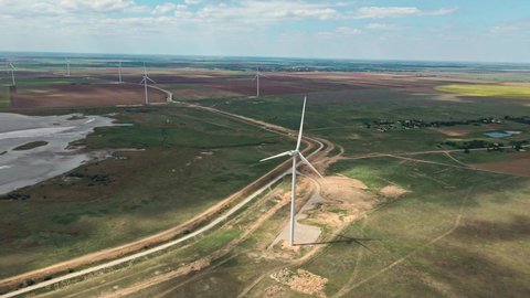 Aerial view of wind turbines farm for energy production on field background. Wind power turbines generating clean renewable energy for sustainable development.