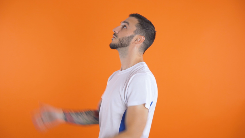 Happy confident football player in white blue shirt throwing in air soccer ball