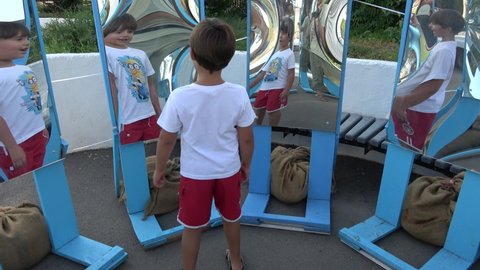 Kherson, Ukraine - 8th of September 2020: 4K Child has fun in the house of mirrors looking on his reflections
