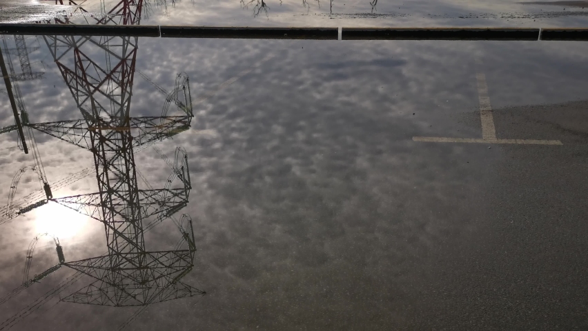 footage of looking on the reflective puddle of electric supply tower., a Buildings & Landmark Video by Young Swee Ming