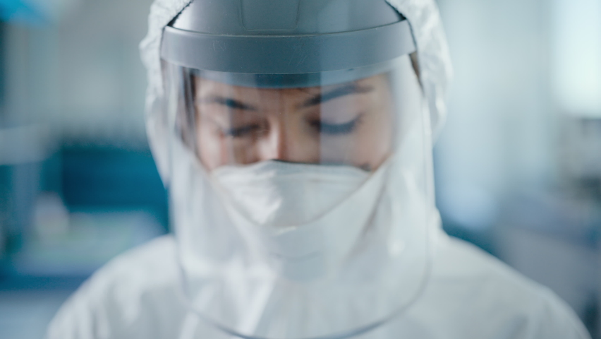 Dramatic Shot of Heroic and Overworked Medical Worker Wearing Coverall, Face Mask and Shield Looks Up at the Camera with His Piercing but Hopeful Eyes. Health Worker Fighting against Pandemic | Shutterstock HD Video #1059497969