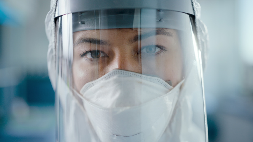 Dramatic Shot of Heroic and Overworked Medical Worker Wearing Coverall, Face Mask and Shield Looks Up at the Camera with His Piercing but Hopeful Eyes. Health Worker Fighting against Pandemic | Shutterstock HD Video #1059497969