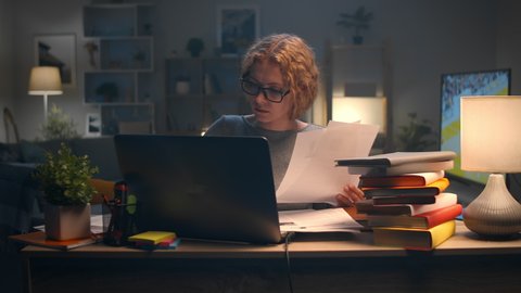 Young beautiful woman working on laptop late at night in her apartment