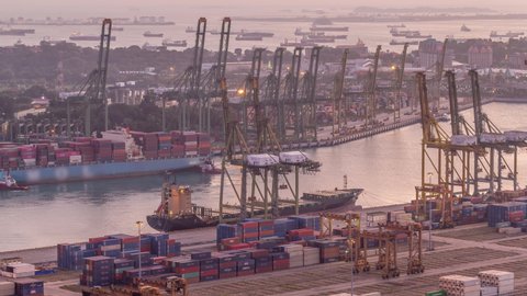 Commercial port of Singapore aerial day to night transition timelapse. Panoramic view of busiest Asian cargo port with hundreds of ships loading export and import goods and thousands of containers in