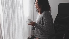 Elderly woman drinking coffee by the window in the morning. - Powered by Shutterstock - Get 15% off with code: PIKWIZARD15
