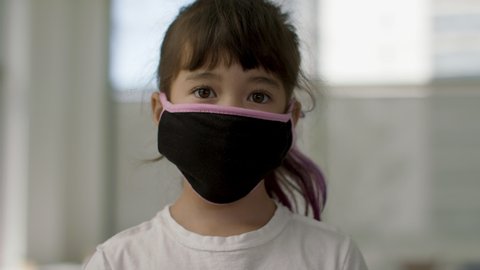 Masks On. Back to school and practicing safety measures. A young girl in a mask stands for a portrait.  Shot in 4k. 