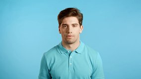 Frustrated european man over blue wall background. Guy is tired, bored of work or studying, he disappointed, helpless