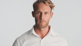 Handsome blond bearded businessman in shirt confidently preening looking in camera as mirror over white background
