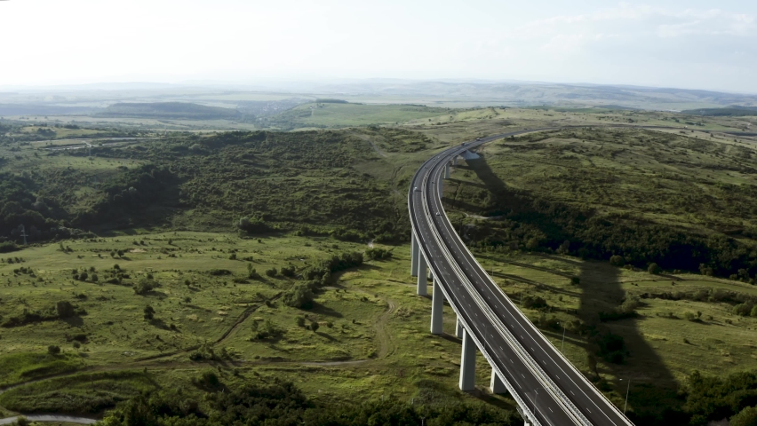Aerial View of cars driving on elevated highway over green forest