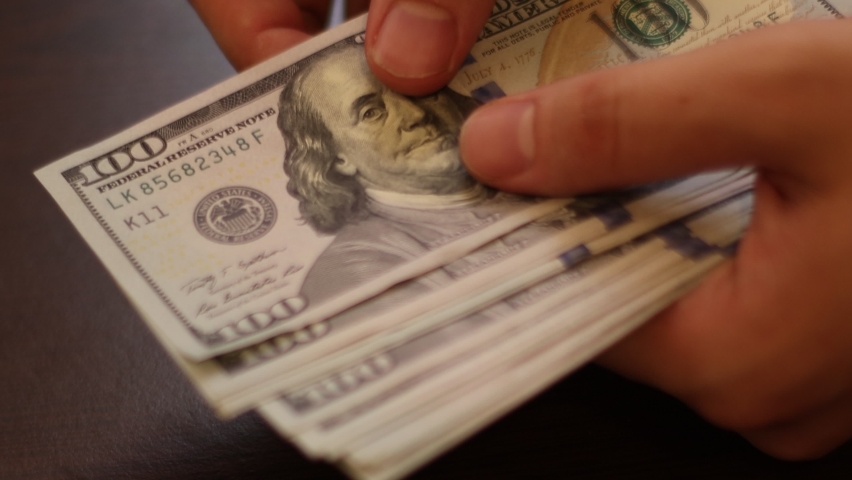 Hands counting US Dollar bills or paying in cash on money background. Concept of investment, success, financial prospects or career advancement. Royalty-Free Stock Footage #1059539252