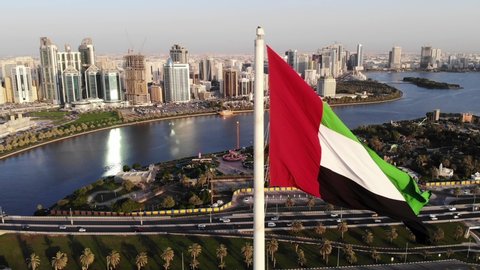 Sharjah, Aerial view of UAE flag waving in the sky over Flag Island in Sharjah. UAE flag day, Sharjah Flag Island