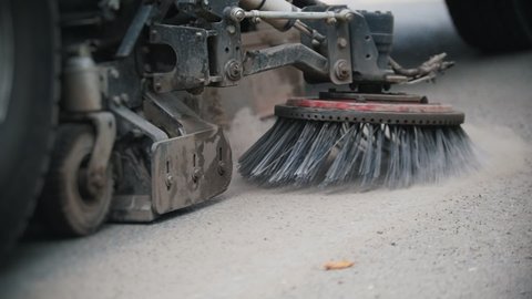 Machine clears the asphalt with a sweeper from the concrete dust