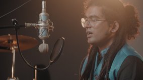 Professional indian singer, man in rehearsal studio, music production, big music event, traditional hindi music. Male singing song on radio, video streaming