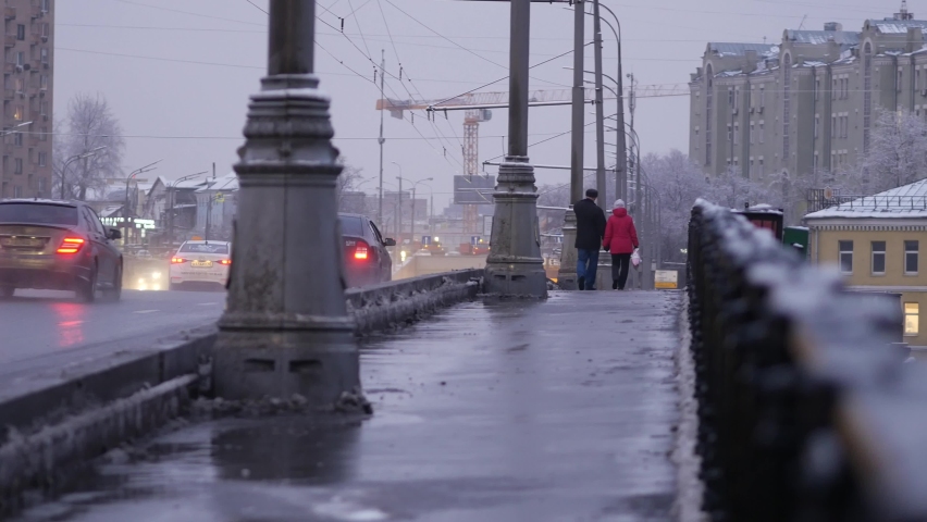 Evening city in snow after heavy snowfall. People walk across the bridge of Moskva River at dusk. Beautiful landscape views in winter of historic center. Frosty winter day in January. Snowy winter. Royalty-Free Stock Footage #1059546752