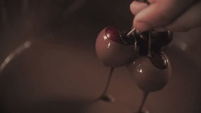 Dipping cherries into melted chocolate. Shoot on Digital Cinema Camera in slow motion - ProRes 422 codec.