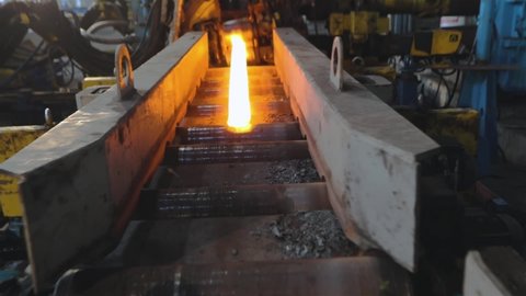 Rolling metal in production, moving on a hot metal ribbon, ball production phase, production process at a metal rolling plant, rolling through sparkling metal rollers