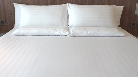 White Sheets and Pillows on King Size Bed in Comfortable Suite Bedroom, Tilt Up