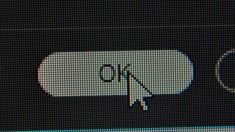 The cursor arrow moves across the screen and clicks on the OK button. Screen monitor pixels close up. Red, blue and green subpixels create the image on the screen.